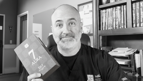 Dr. John Zannis holding a box of SIX7 olfactory neurodesigned fragrance