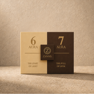 A square product box for Zannis Aura stands on a textured beige surface against a matching beige wall. The box is split vertically into a light beige left half labeled '6 AURA' and a dark brown right half labeled '7 AURA', with a small central dark brown badge reading 'Z ZANNIS'.